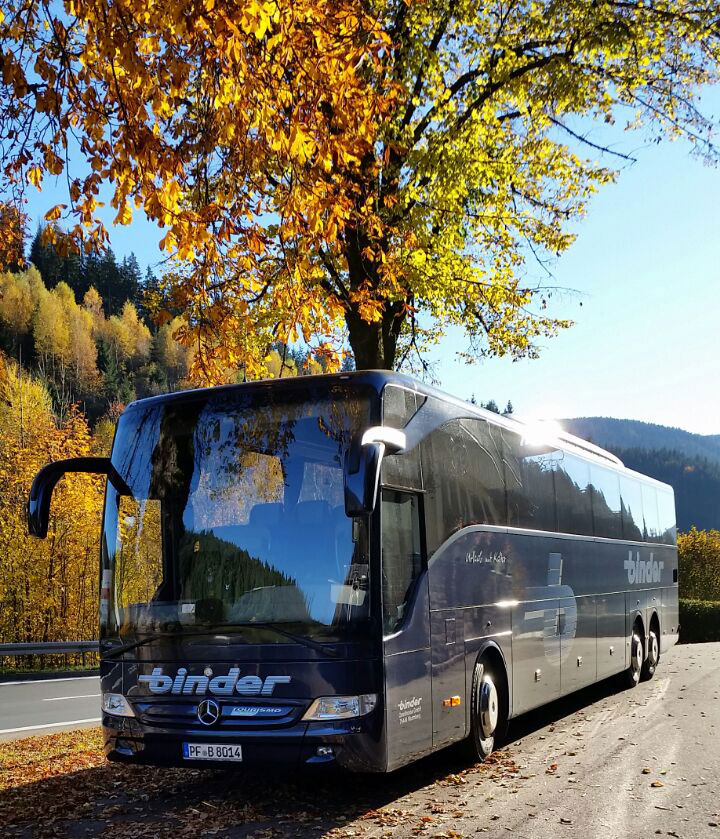 Reisebus in herbstlicher Landschaft